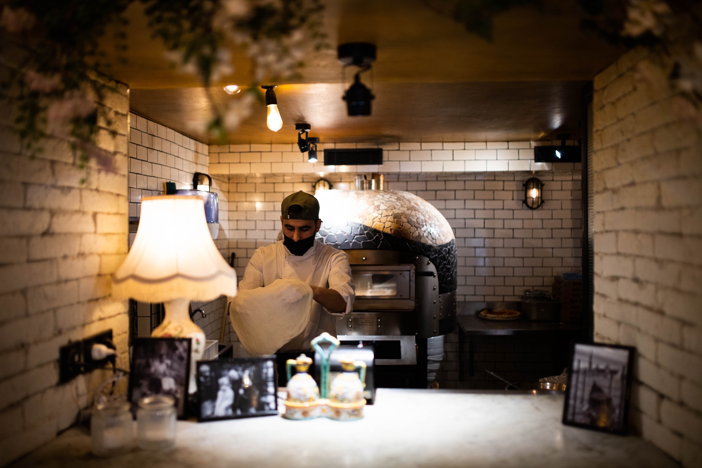Le pizzaiolo prépare la pâte devant le four